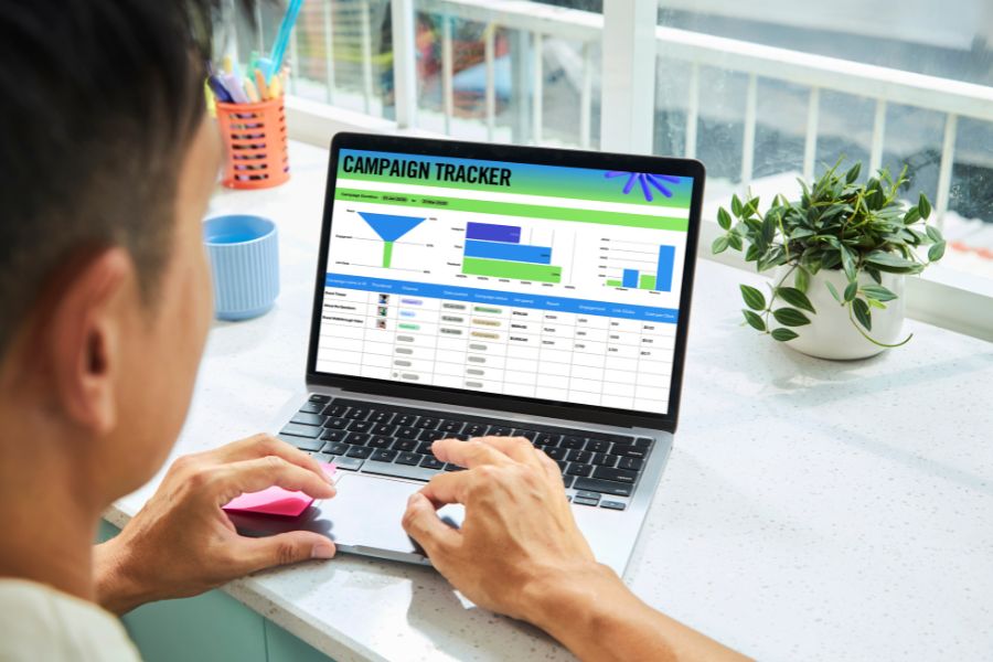 Professional analyzing silent marketing campaigns data on laptop with campaign tracker dashboard