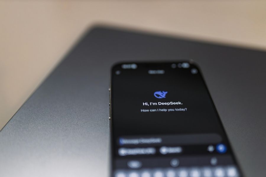 A smartphone displaying the DeepSeek application interface on a dark metallic surface.